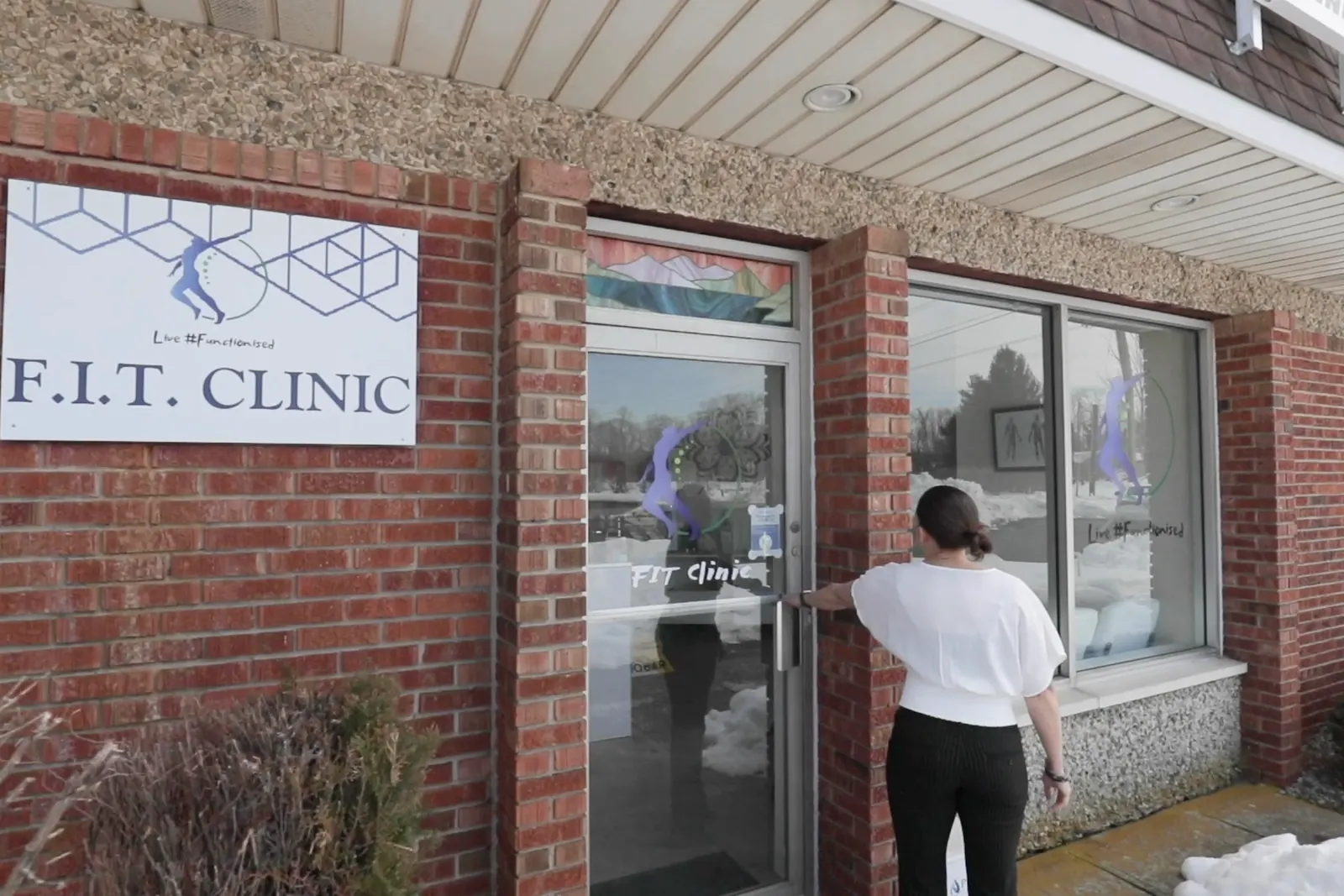 The front door of FIT Clinic below its wall sign at 8 Merchants Way in Colts Neck