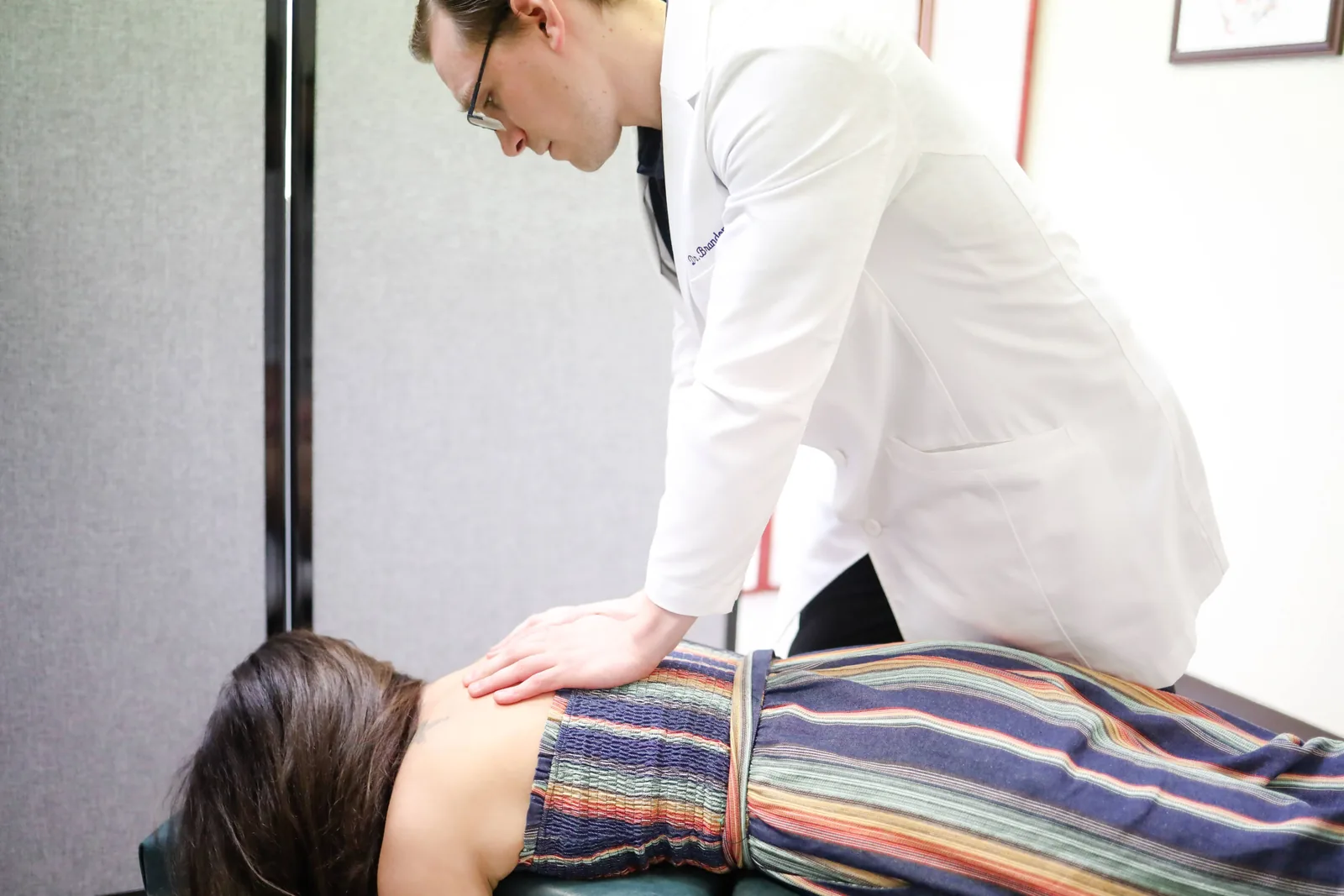 Dr. Michael Brandon, DC, during a back evaluation at FIT Clinic