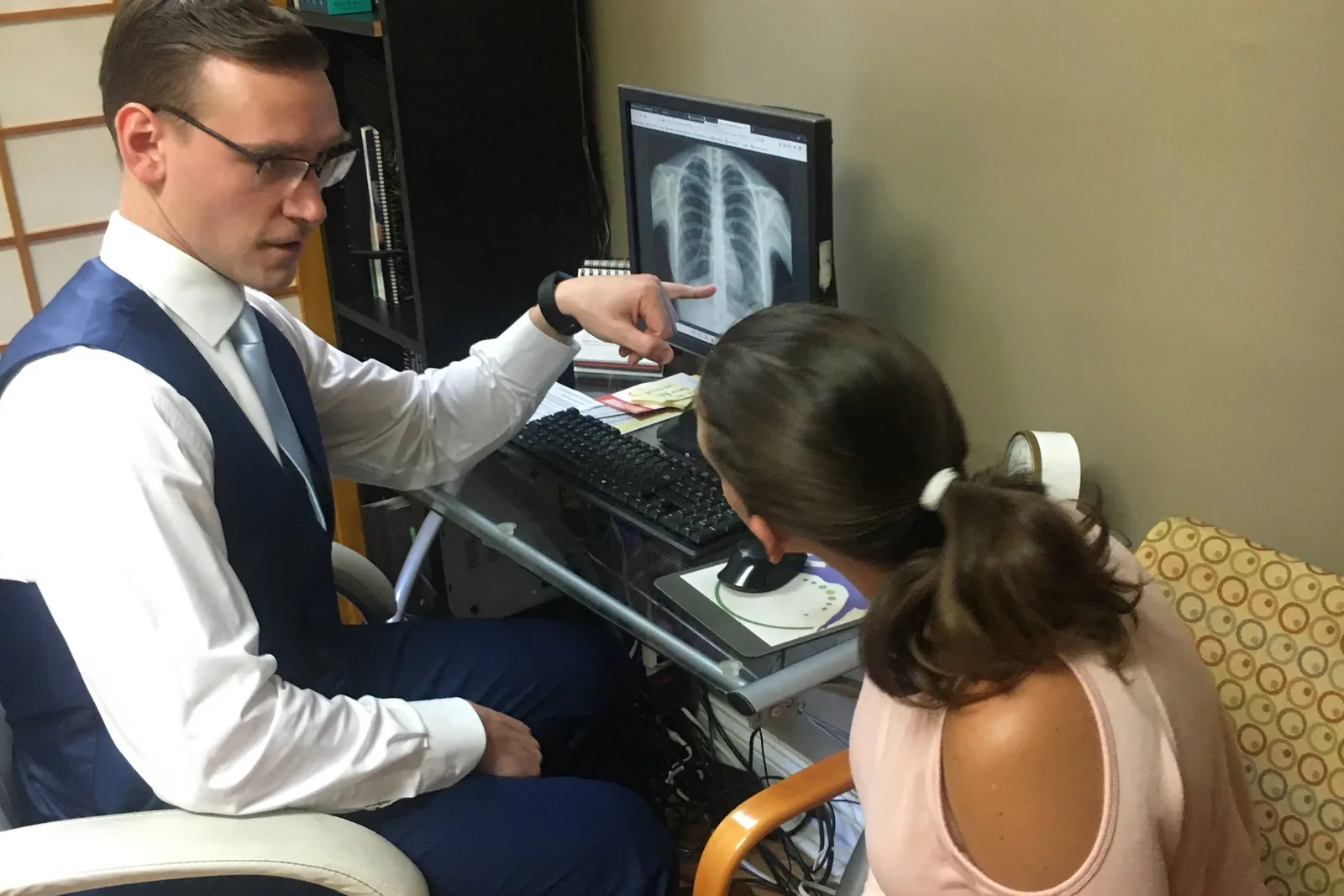 Dr. Brandon explaining findings to a patient seated beside him at FIT Clinic